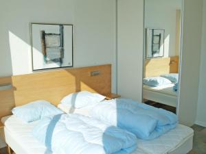 łóżko z niebieską kołdrą w sypialni w obiekcie Holiday Home Sophy - 2km from the sea in Western Jutland by Interhome w mieście Havneby