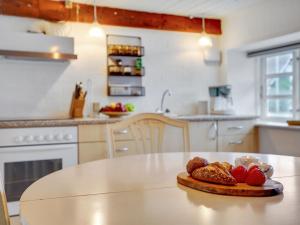 una cocina blanca con una mesa con fresas. en Holiday Home Miko - 19km from the sea in Western Jutland by Interhome en Skærbæk