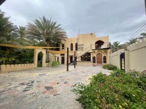 a house with a courtyard with a palm tree at Date Palm Inn in Nizwa