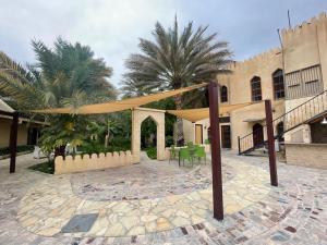 a patio with a tent and a table in front of a building at Date Palm Inn in Nizwa