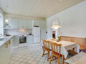 eine Küche und ein Esszimmer mit einem Tisch und Stühlen in der Unterkunft Holiday Home Jonni - 15km from the sea in Western Jutland by Interhome in Skærbæk