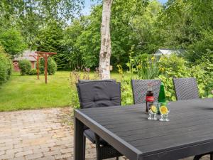 a wooden table with two bottles and glasses on it at Holiday Home Jonni - 15km from the sea in Western Jutland by Interhome in Skærbæk