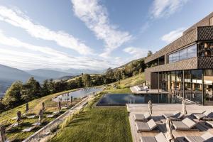 a house on a hill with a pool and chairs at Santre dolomythic home in Bressanone