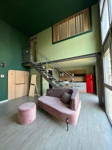 ein Wohnzimmer mit einem Sofa und einer Treppe in der Unterkunft Unico Studios in Mailand