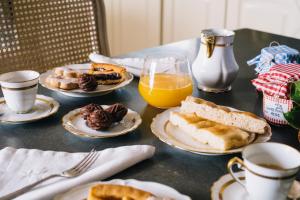 een tafel met borden ontbijtproducten en jus d'orange bij VILLA AGA in Noli