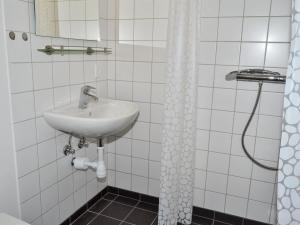 uma casa de banho branca com um lavatório e um chuveiro em Apartment Baltser - 5km from the sea in Western Jutland by Interhome em Kongsmark