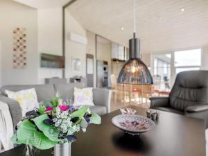 a living room with a table with a vase of flowers on it at Holiday Home Damiana - 500m from the sea by Interhome in Sarup