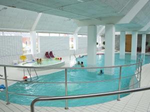 a large indoor swimming pool with people in it at Apartment Aapeli - 2km from the sea in Western Jutland by Interhome in Sønderby