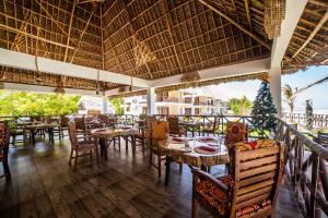 um restaurante com mesas e cadeiras e uma árvore de Natal em Mahi Mahi Beach Hotel em Jambiani