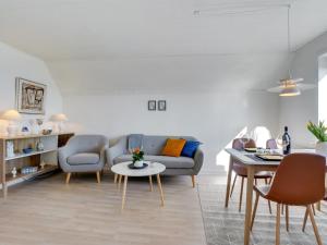 a living room with a couch and a table at Apartment Herkko - 25m from the sea in Western Jutland by Interhome in Esbjerg