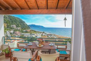 グリファダにあるSuzanne's Apartment Glyfada Menigos Resortのテーブルと椅子、海の景色を望むバルコニー