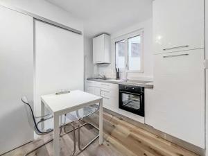 una cucina bianca con un piccolo tavolo bianco di Bright studio in the center of Montreux a Montreux
