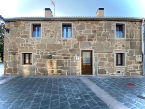 a stone building with a door in front of it at Marujita Vilanova, alojamiento singular in Villanueva de Arosa