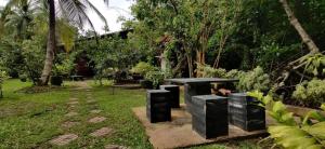 ein Park mit einer schwarzen Bank im Gras in der Unterkunft Mangrove Paradise Resort & spa in Galle