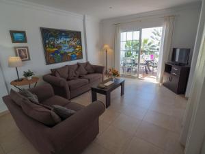 sala de estar con sofá, mesa y TV en Nerja Paradise Rentals - Villa Las Brisas, en Nerja