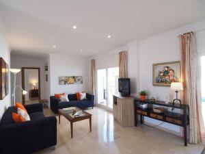 ein Wohnzimmer mit einem Sofa und einem TV in der Unterkunft Nerja Paradise Rentals - Villa Las Dalias in Nerja