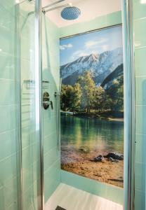 a bathroom with a shower with a painting of a mountain at Hotel Rolly in Riva del Garda