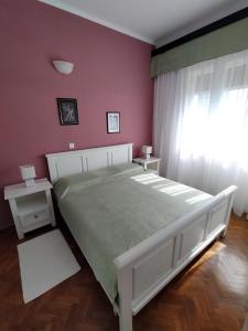 a bedroom with a large bed with pink walls at Apartments Ivna Bilek in Opatija