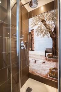 a shower stall with a painting of a tree at Hotel Rolly in Riva del Garda