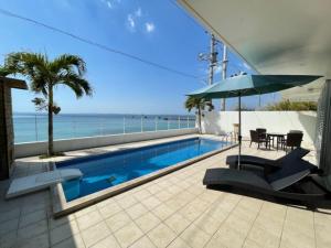 金武町にあるMarina Kin - Vacation STAY 48755vのテーブルと傘が備わるスイミングプールと海