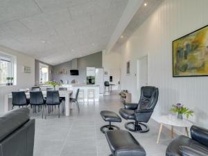 a living room with chairs and a dining room at Holiday Home Gardi - 14km from the sea by Interhome in Oksbøl