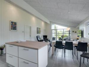 a kitchen and dining room with a table and chairs at Holiday Home Gardi - 14km from the sea by Interhome in Oksbøl