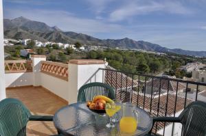 einen Tisch mit einer Obstschale auf dem Balkon in der Unterkunft Nerja Paradise Rentals - Apt Chimenea C2D in Nerja