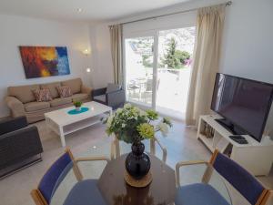 uma sala de estar com uma televisão e uma mesa e cadeiras em Nerja Paradise Rentals - Villa Ambar em Nerja