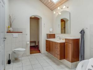 ein Badezimmer mit einem WC, einem Waschbecken und einem Spiegel in der Unterkunft Holiday Home Birita - 20km from the sea in Western Jutland by Interhome in Ribe