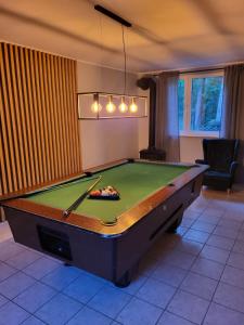 a pool table in a living room with at Dom Wypoczynkowy Zacisze- klimatyczny domek z kominkiem in Stegna