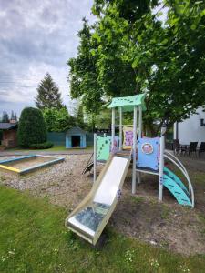 a playground with a slide in a yard at Dom Wypoczynkowy Zacisze- klimatyczny domek z kominkiem in Stegna