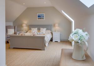 a bedroom with a bed and a vase of flowers at Little Owl Loft in Attlebridge
