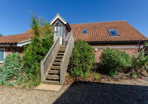 a house with a staircase leading up to a house at Little Owl Loft in Attlebridge