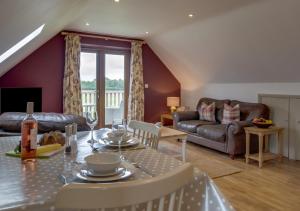 a living room with a table and a couch at Little Owl Loft in Attlebridge