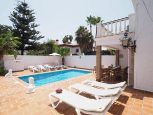 een zwembad met witte stoelen en een tafel en een zwembad bij Nerja Paradise Rentals - Villa Los Leones in Nerja