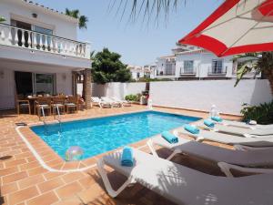 een zwembad met ligstoelen en een parasol bij Nerja Paradise Rentals - Villa Los Leones in Nerja