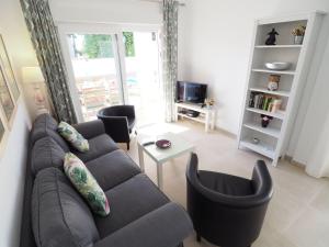 uma sala de estar com um sofá e cadeiras e uma televisão em Nerja Paradise Rentals - Villa Bonilla em Nerja