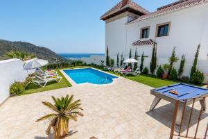 a villa with a swimming pool and a house at Nerja Paradise Rentals - Villa Cataleya in Frigiliana