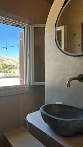 a bathroom with a stone sink and a mirror at Amalthea Luxury Suites in Symi