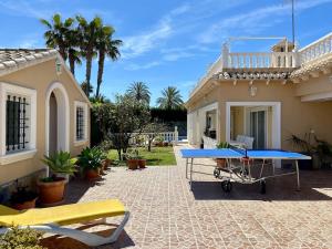 uma mesa de pingue-pongue azul em frente a uma casa em Casa Nieves Cabo roig em Orihuela