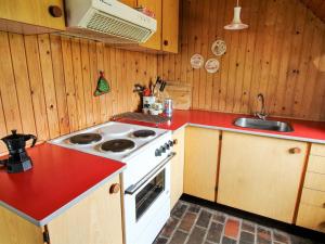 eine Küche mit einem weißen Herd und einer roten Arbeitsplatte in der Unterkunft Holiday Home Ilva - 300m to the inlet in Western Jutland by Interhome in Ulfborg