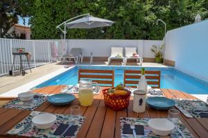 stół z jedzeniem i napojami na drewnianym stole przy basenie w obiekcie Nerja Paradise Rentals - Villa Suero w mieście Nerja