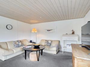 een woonkamer met 2 banken en een tafel bij Holiday Home Fransiska - from the sea in Western Jutland by Interhome in Ulfborg