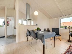 een keuken en eetkamer met een tafel en stoelen bij Holiday Home Duschanka - 50m to the inlet in SE Jutland by Interhome in Fredericia