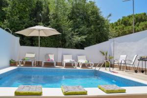 - une piscine avec des chaises et un parasol dans l'établissement Nerja Paradise Rentals - Villa Valeria, à Nerja