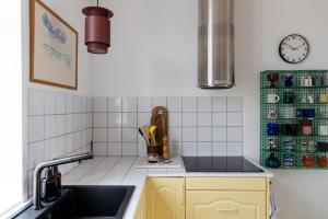a kitchen with yellow cabinets and a sink at 18b Ferielejlighed in Harboør