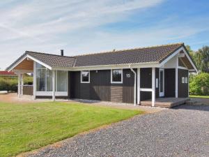 a black and white house with a yard at Holiday Home Sondra - 250m from the sea in SE Jutland by Interhome in Børkop