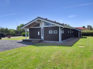 a brown building with a grassy yard in front of it at Holiday Home Sondra - 250m from the sea in SE Jutland by Interhome in Børkop
