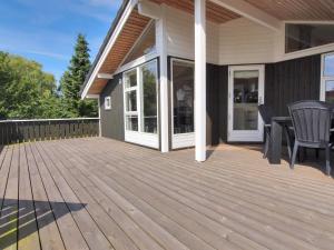 a wooden deck with chairs on a house at Holiday Home Sondra - 250m from the sea in SE Jutland by Interhome in Børkop