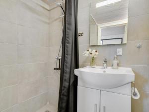 y baño blanco con lavabo y ducha. en Apartment Thessa - 900m from the sea in SE Jutland by Interhome, en Juelsminde